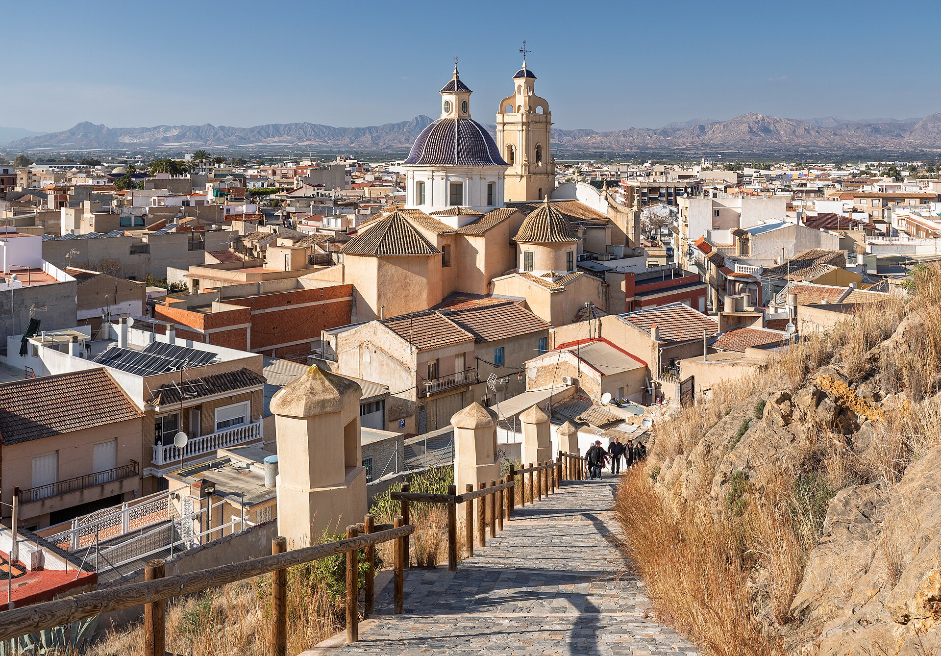 Iglesia parroquial de San Juan Bautista y el casco urbano de Cox desde el camino al castillo