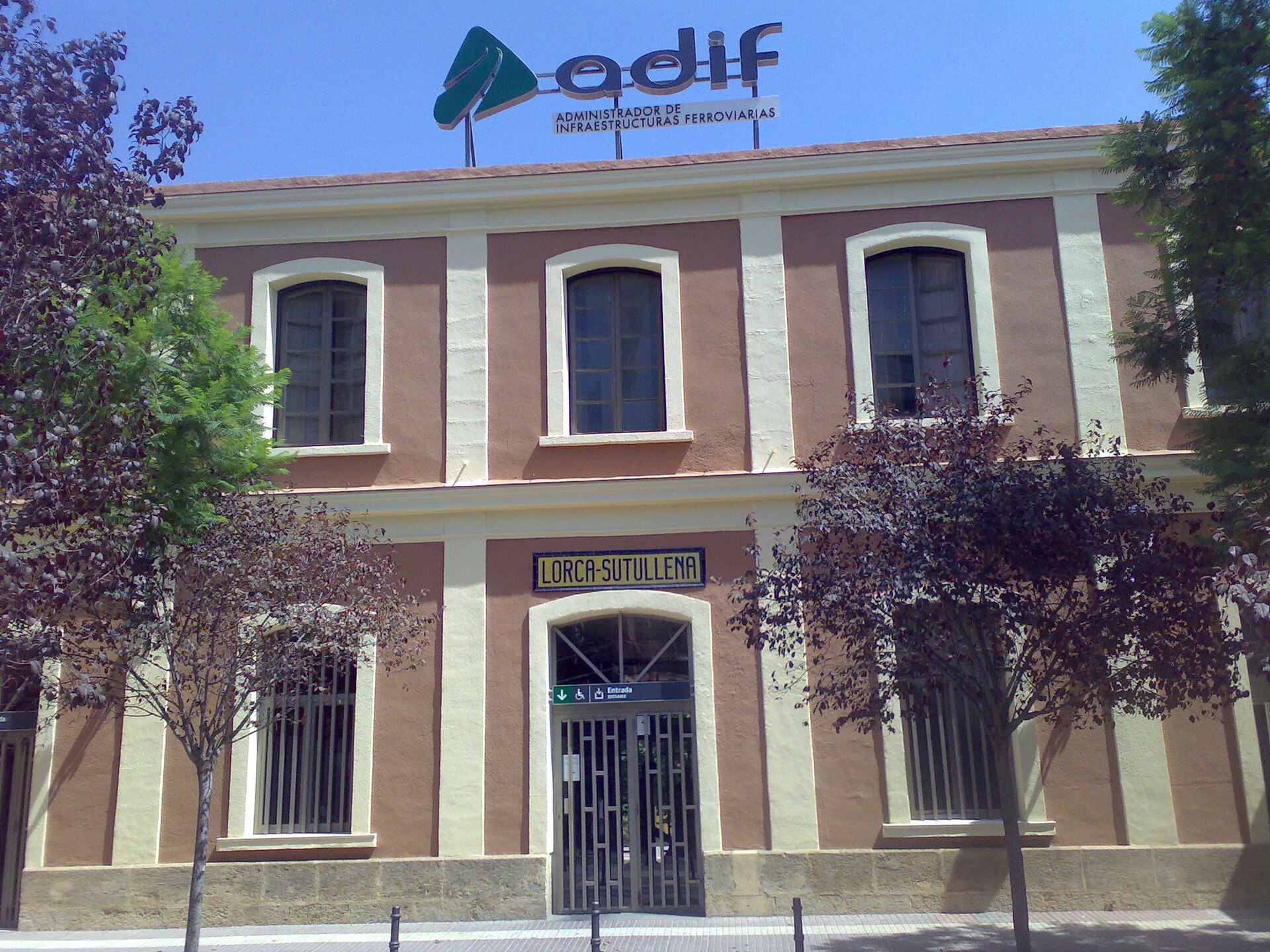Fachada de la estación Lorca‑Sutullena con cartel y rótulo ADIF