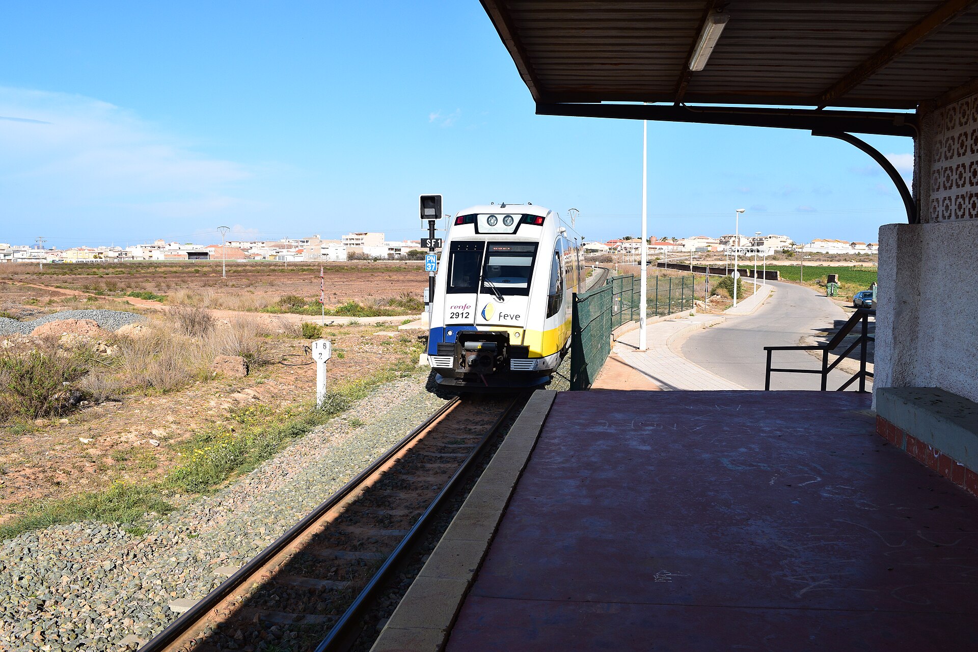 Tren en la estación de Los Nietos Viejos y paisaje abierto
