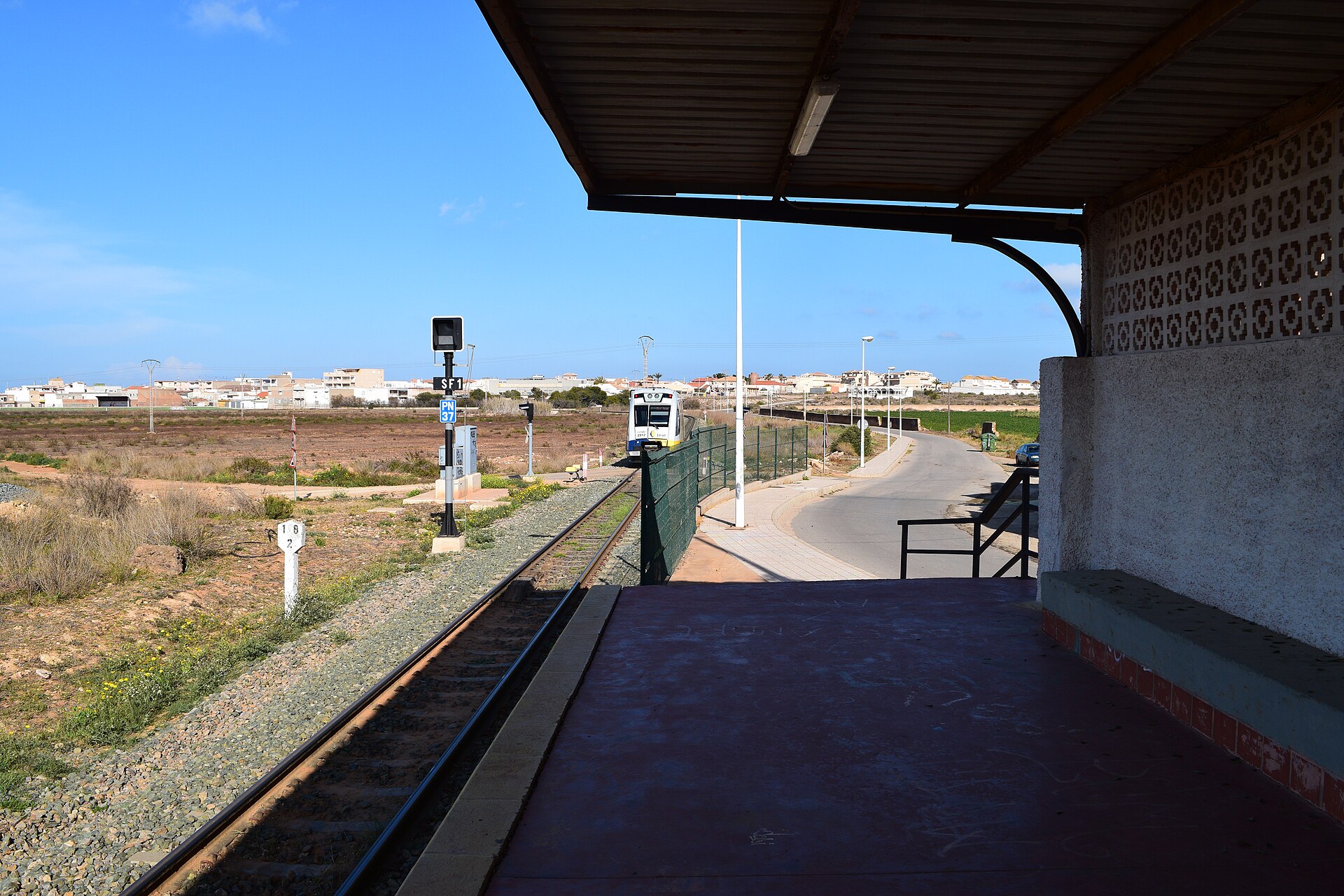 Andén de Los Nietos Viejos con vía y paisaje llano