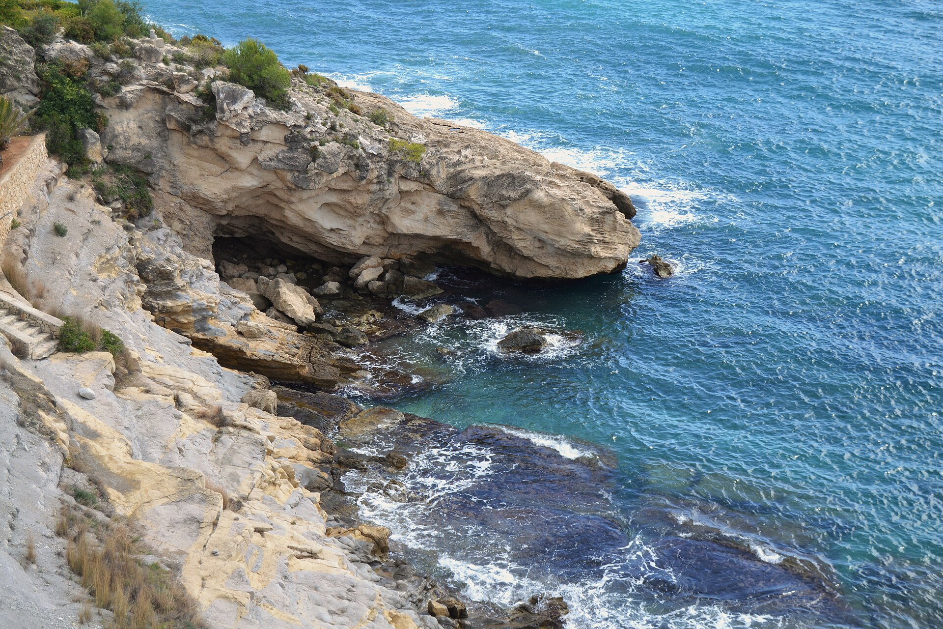 Rincón rocoso y agua azul en la Cala del Portitxol