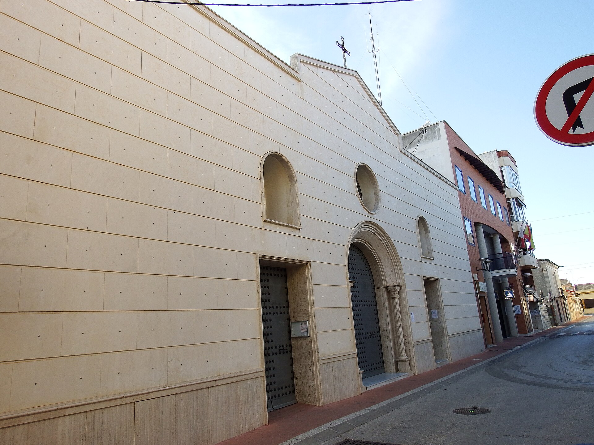 Fachada lateral de la iglesia de San Fulgencio con puertas y muro